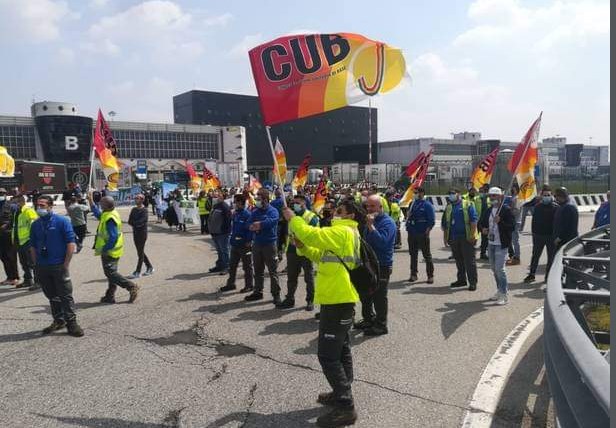 I soci della CUB Trasporti in sciopero all'aeroporto partenza Malpensa, Milano, per migliori salari e condizioni di lavoro.
